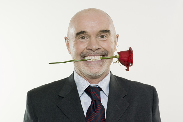 man with rose between his teeth