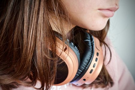 girl wearing wireless headphones on her neck