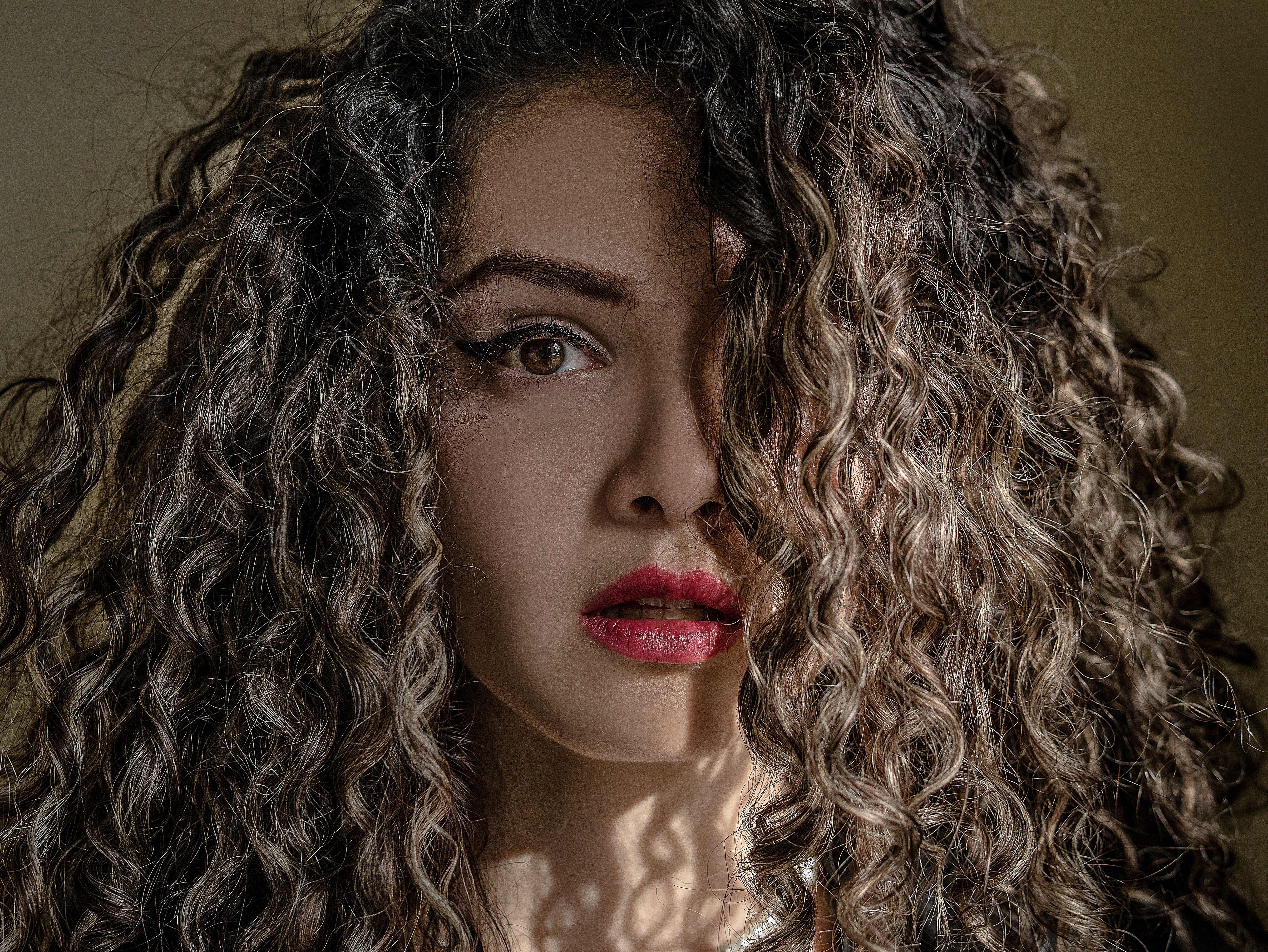 Close up photo of a woman with curly hairstyle